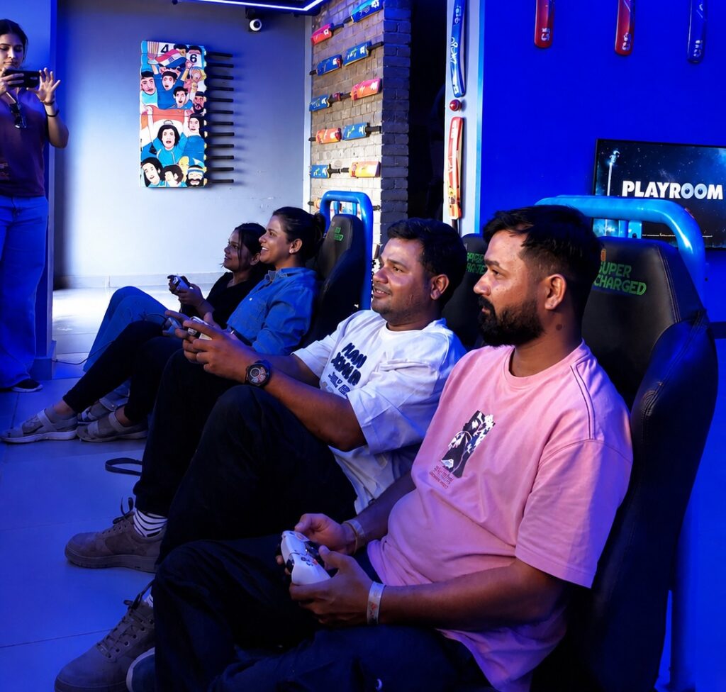 Group of people sitting on gaming chairs playing video games in a blue-lit playroom with cricket bat decorations on the wall